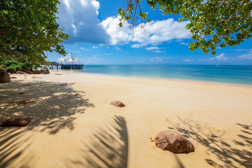 Ein Strand mit einem kleinen Boot im Hintergrund