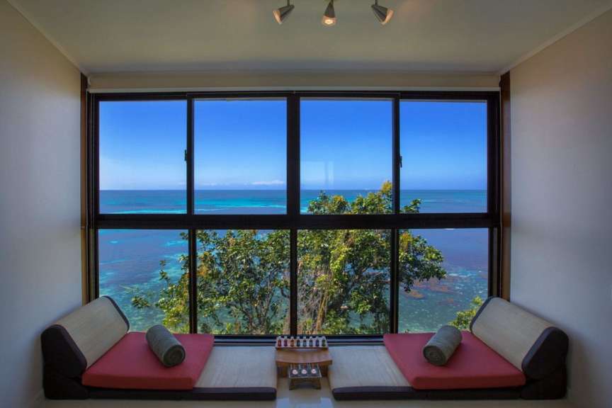 Ein Wohnzimmer mit einem großen Fenster mit Blick auf das Meer