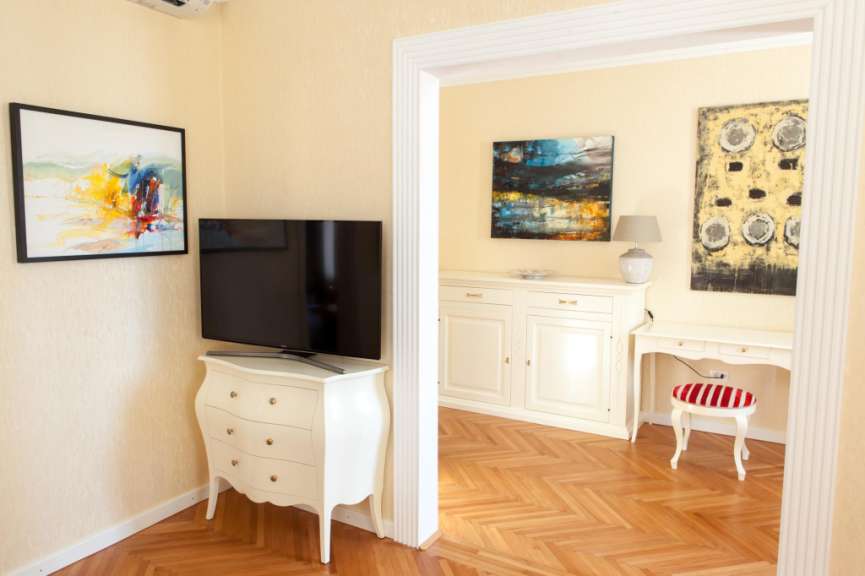 Ein Wohnzimmer mit einem Fernseher und zwei Gemälden an der Wand