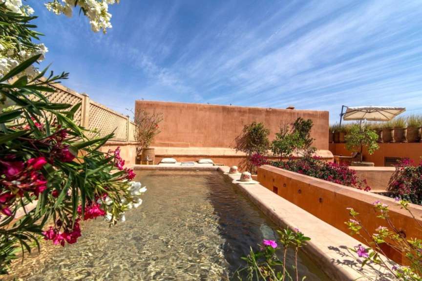Ein großer Pool mit einem roten Gebäude im Hintergrund