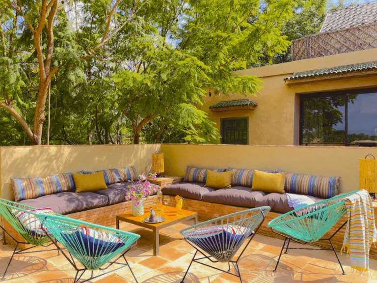 Eine Terrasse mit bunten Stühlen und einem Tisch