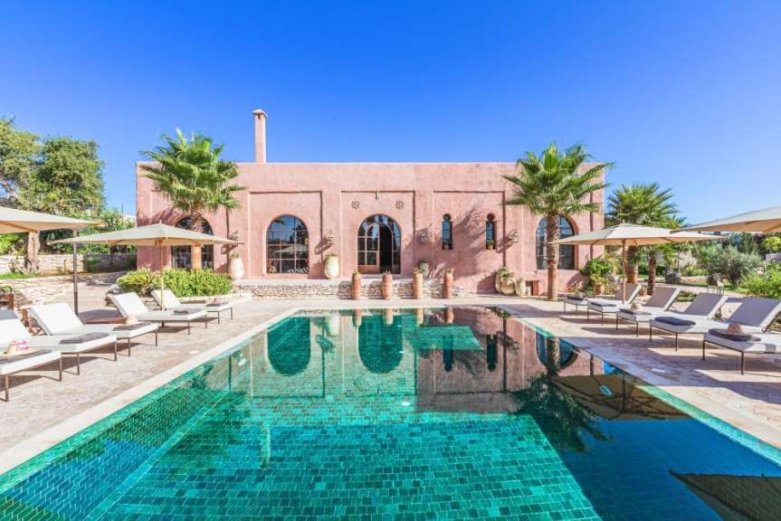 Ein großer Swimmingpool vor einem rosa Gebäude