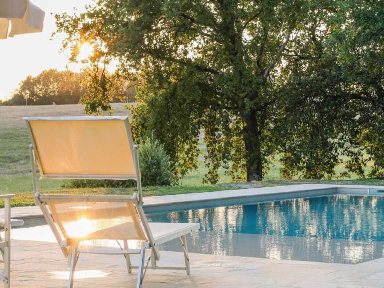 Ein Liegestuhl steht neben einem Swimmingpool