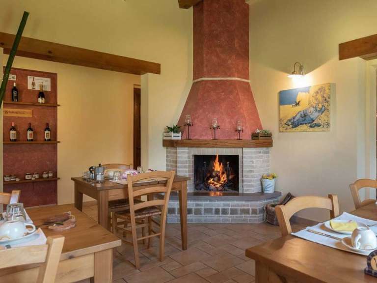 Ein Wohnzimmer mit einem Kamin und einem Tisch und Stühlen