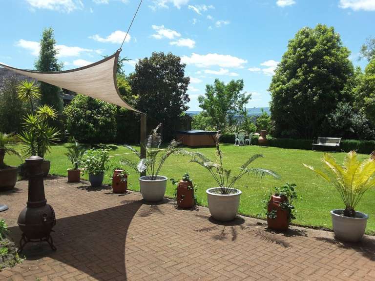 Ein Garten mit vielen Pflanzen und einem Whirlpool im Hintergrund