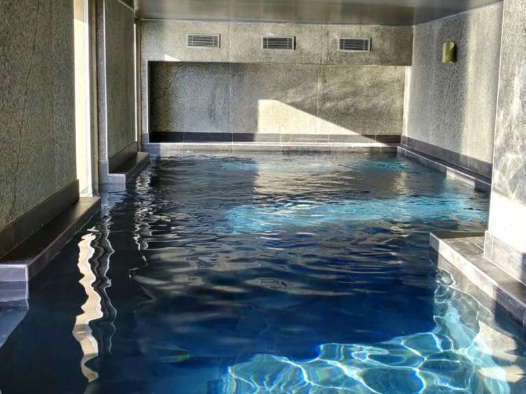 Ein großer Pool mit blauem Wasser in einem Gebäude