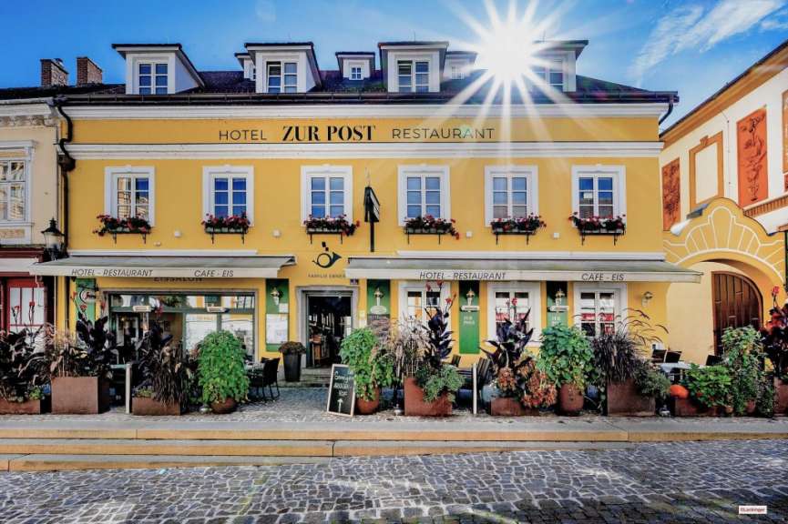 Ein gelbes Gebäude mit der Aufschrift Hotel zur Post Restaurant darauf