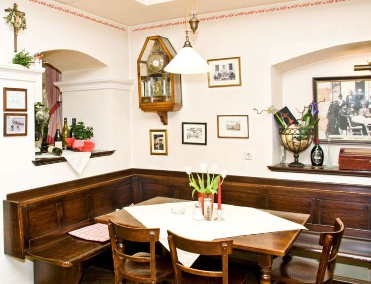 Ein Zimmer mit einem Tisch und Stühlen und einer Uhr an der Wand