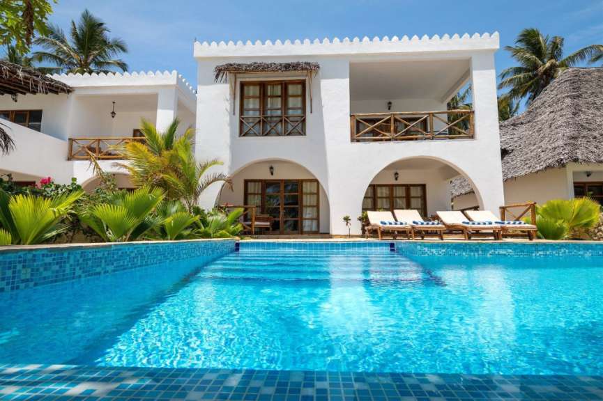 Ein weißes Haus mit einem großen Swimmingpool davor