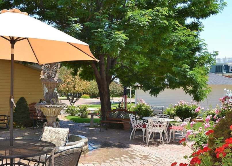 Eine Terrasse mit Tisch und Stühlen und einem Brunnen