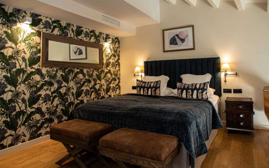 Ein Schlafzimmer mit einem Bett und zwei Hockern
