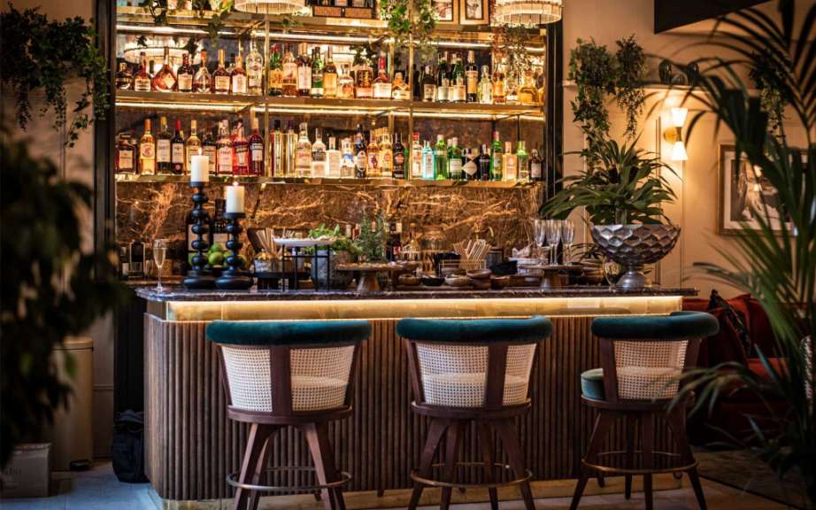 Eine Bar mit Stühlen und Flaschen an der Wand