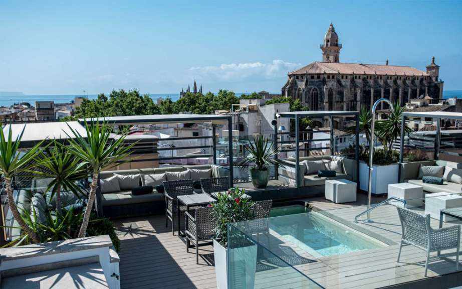 Eine Terrasse mit einem Pool und einer Kirche im Hintergrund