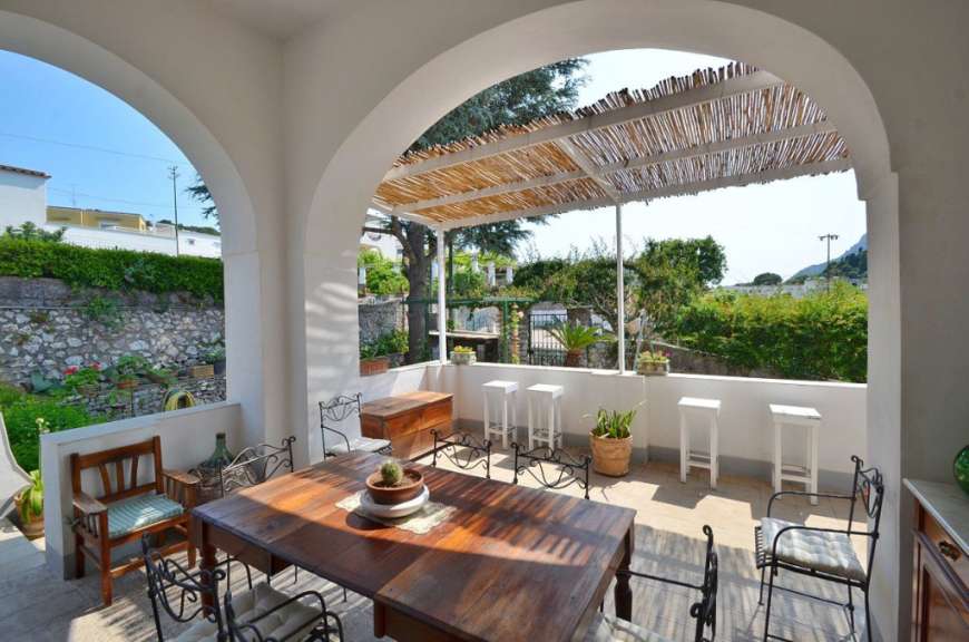 Ein Tisch und Stühle auf einer Terrasse mit einem Strohdach