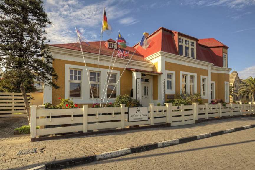 Ein Gebäude mit einem weißen Zaun und einem Schild mit der Aufschrift the charming house