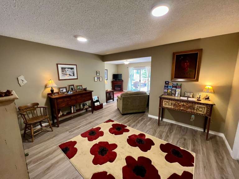Ein Wohnzimmer mit einem Teppich mit roten Blumen darauf