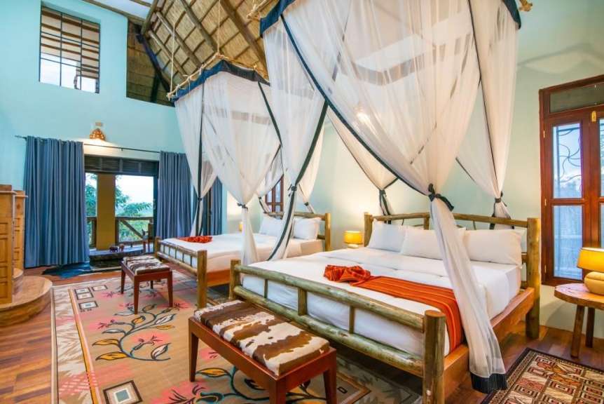 Auf dem Bild ist ein Schlafzimmer mit zwei Betten mit Himmelbetten zu sehen.