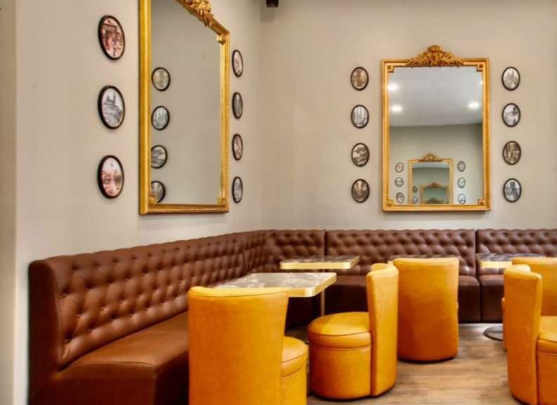 Ein Wohnzimmer mit braunen Ledersofas und gelben Stühlen