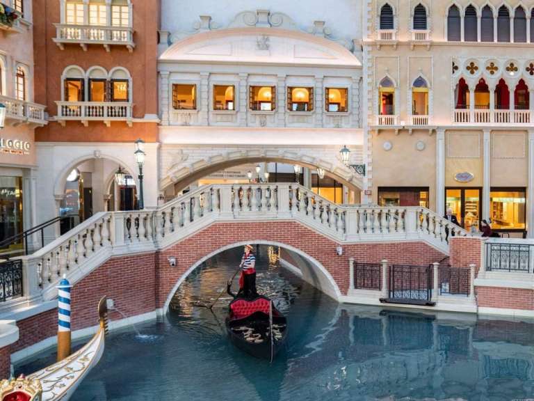 Eine gondola fährt unter einer Brücke in einem Einkaufszentrum