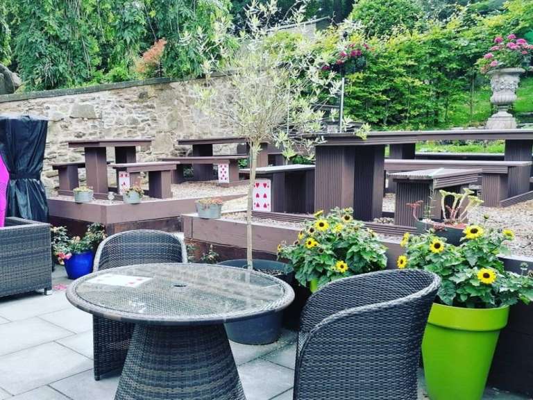 Ein Tisch und Stühle auf einer Terrasse mit Karten auf den Bänken
