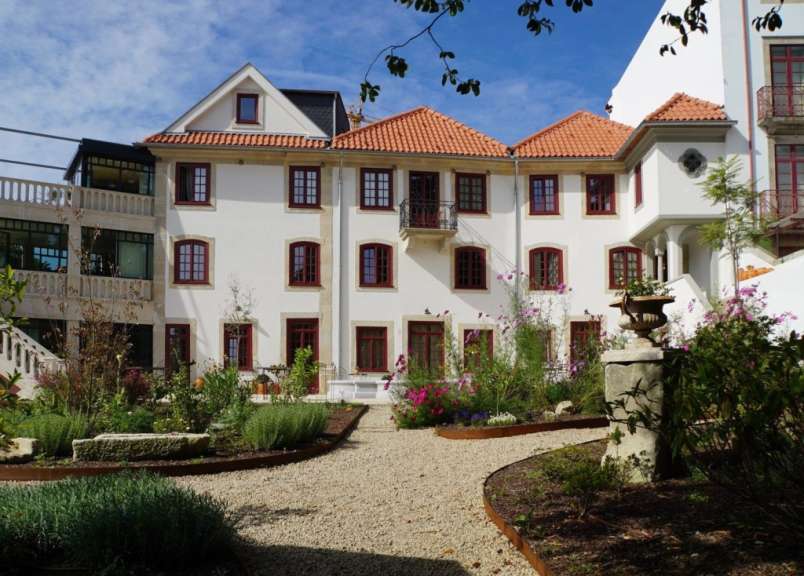 Ein großes weißes Haus mit roten Fenstern und einem roten Dach