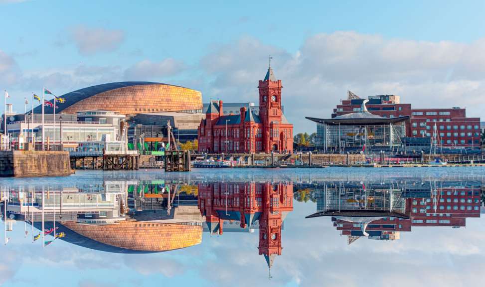 Ein Gebäude mit der Aufschrift ‚ liverpool ‘ darauf spiegelt sich im Wasser