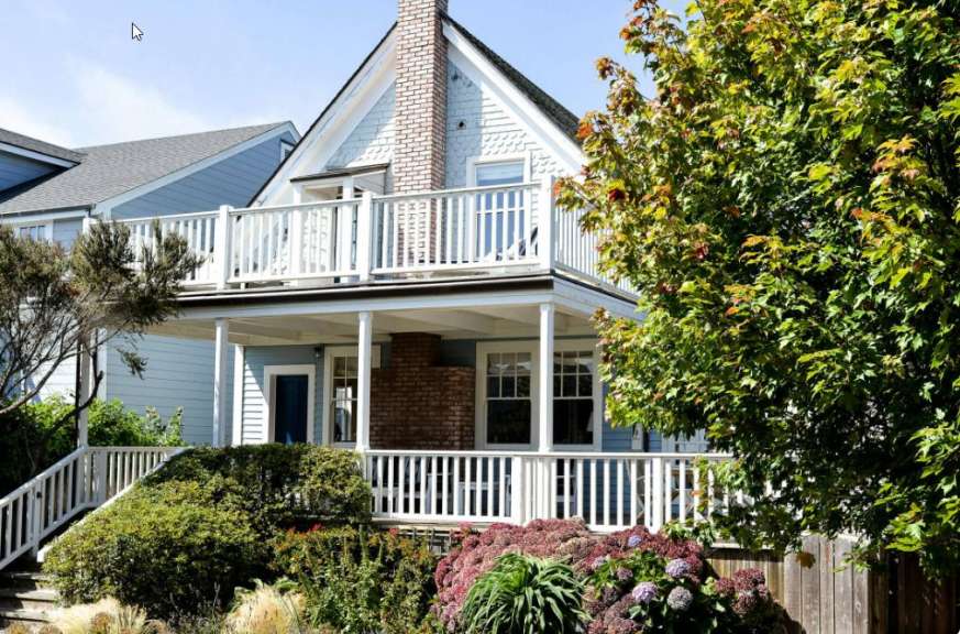 Ein blaues und weißes Haus mit einer weißen Veranda