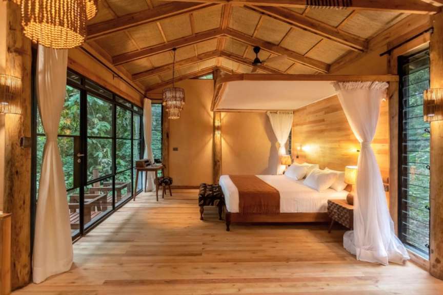 Ein Schlafzimmer mit einem Himmelbett und vielen Fenstern