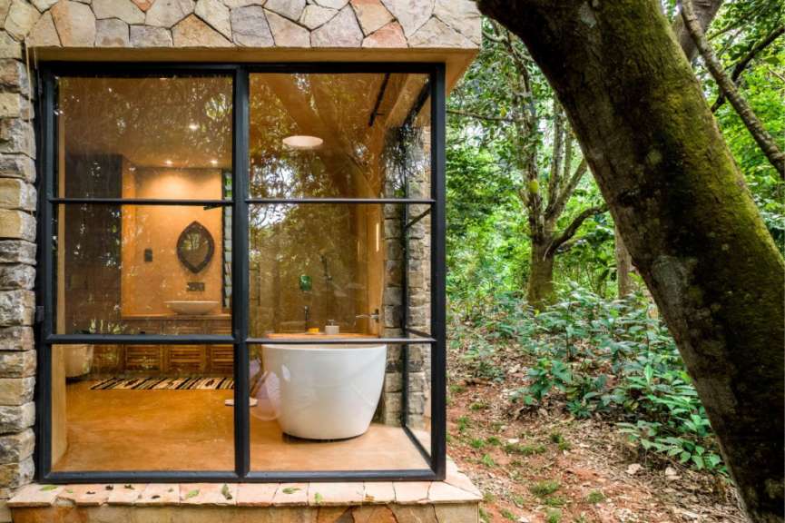 Ein Badezimmer mit einer Badewanne und einem Fenster mit Blick auf den Wald