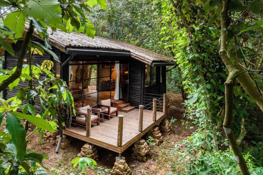 Ein kleines Holzhaus mit einer Holzterrasse im Wald