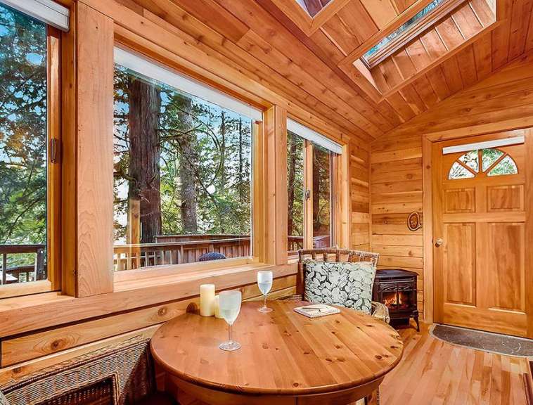 Ein Holzhaus mit einem Tisch und einem Kamin