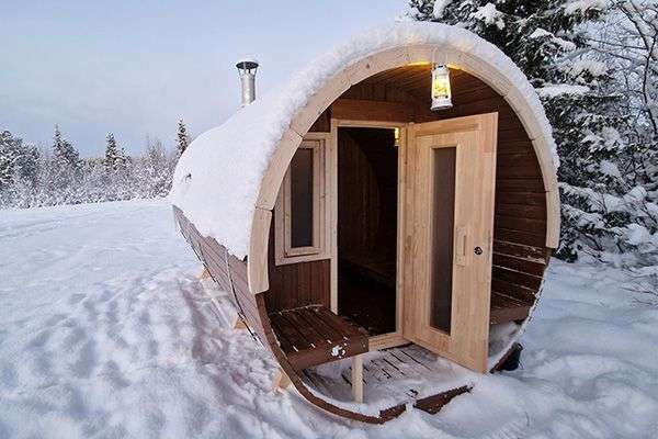 Eine Holzsauna in einem schneebedeckten Feld