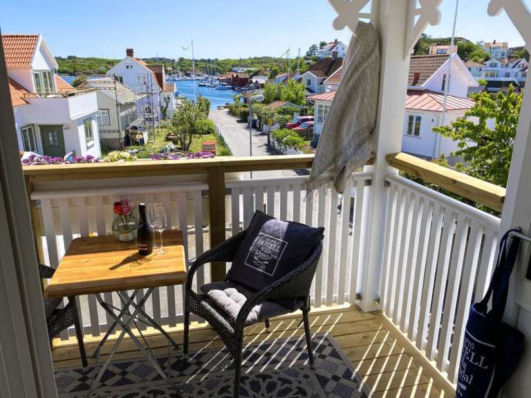 Ein Balkon mit einem Tisch und einem Stuhl und einer Flasche Wein