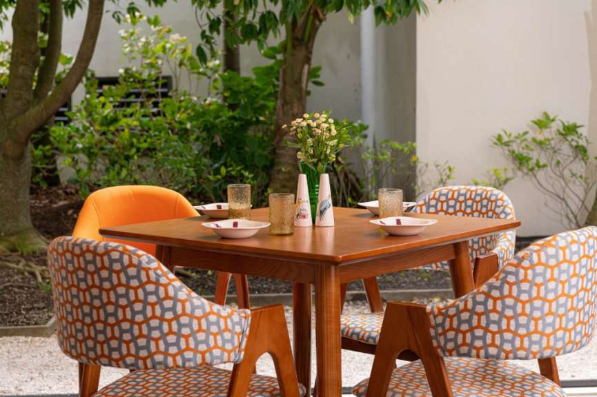 Ein Tisch mit vier Stühlen und einer Vase mit Blumen darauf