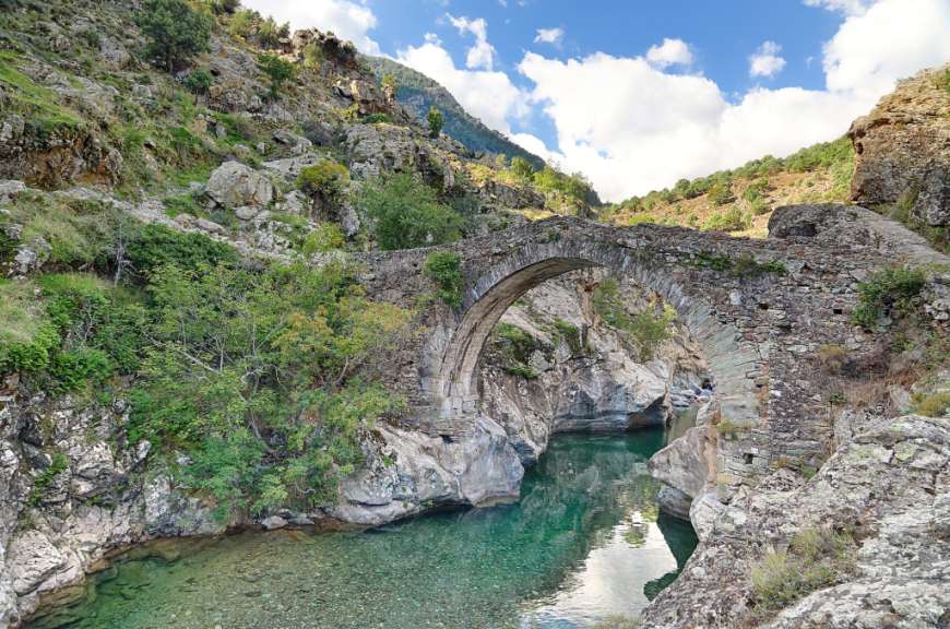 Eine Brücke über einen Fluss in einem Tal
