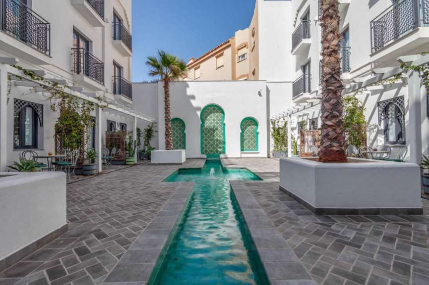 Ein weißes Gebäude mit einem grünen Fenster und einem Pool