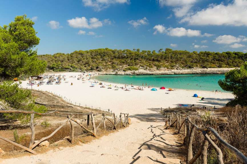 Eine Treppe führt zu einem weißen Sandstrand