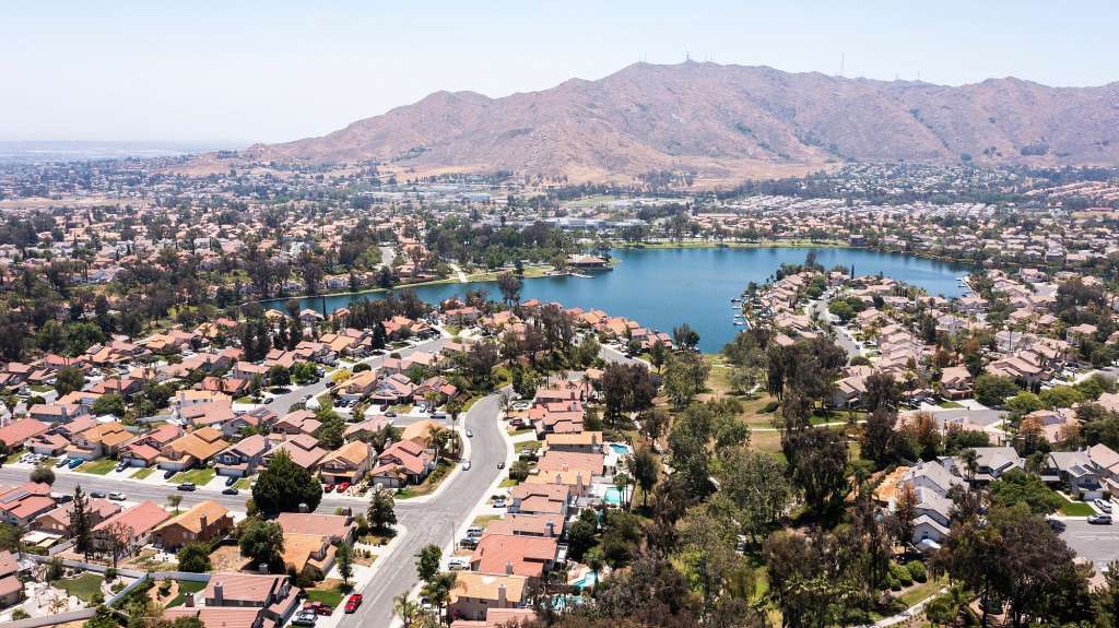 Eine Luftaufnahme einer Wohngegend mit einem See und Bergen im Hintergrund