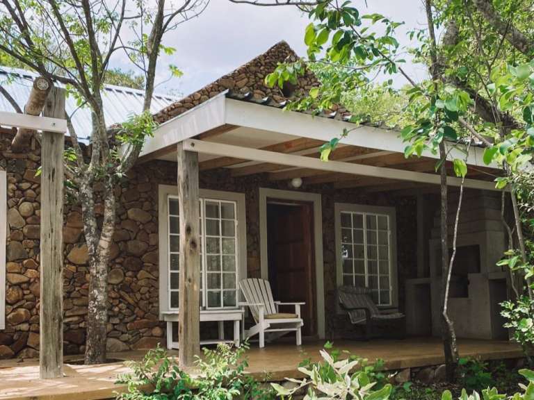 Ein Steinhaus mit einer Veranda und zwei Stühlen darauf