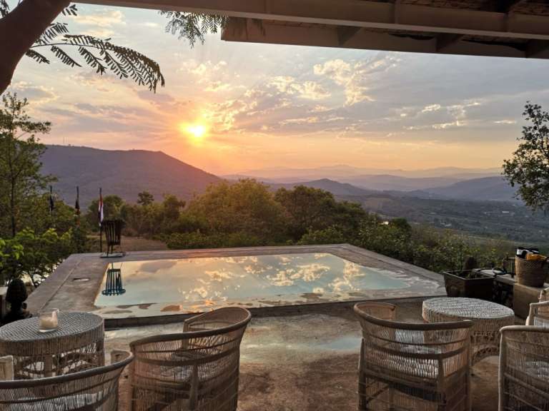 Ein Swimmingpool mit Blick auf die Berge bei Sonnenuntergang