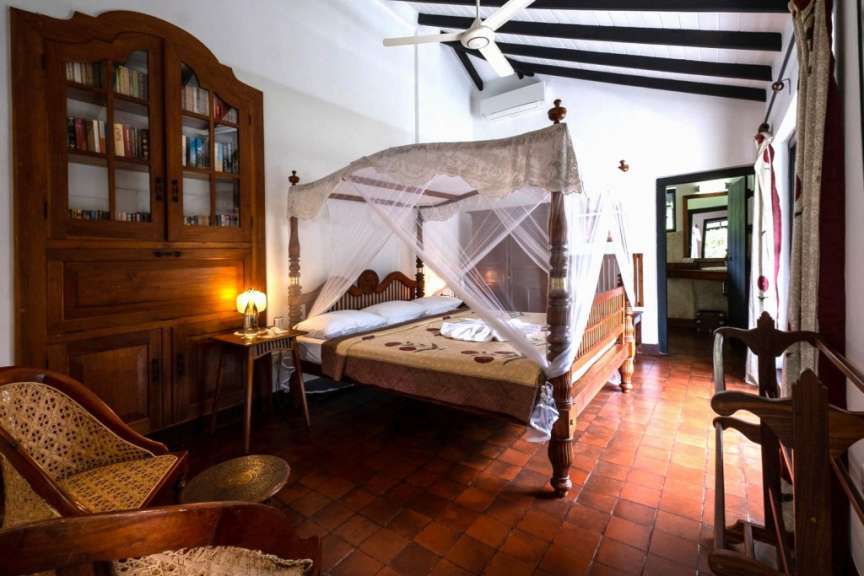 Ein Schlafzimmer mit einem Himmelbett und einem Bücherregal