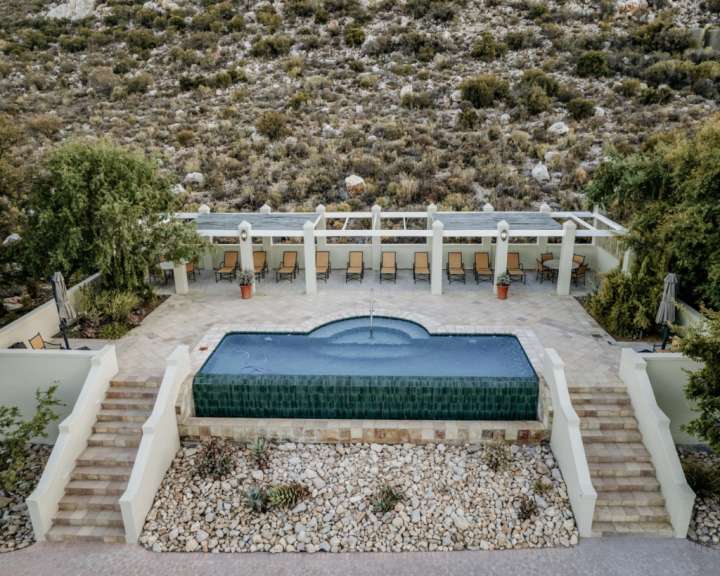 Ein großer Pool mit vielen Stühlen und Treppen davor