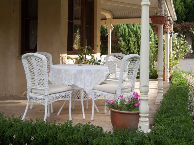 Ein weißer Tisch und Stühle auf einer Veranda