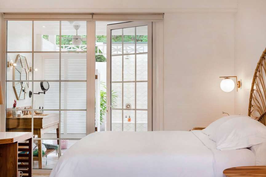 Ein weißes Schlafzimmer mit einem Bett und einem Spiegel