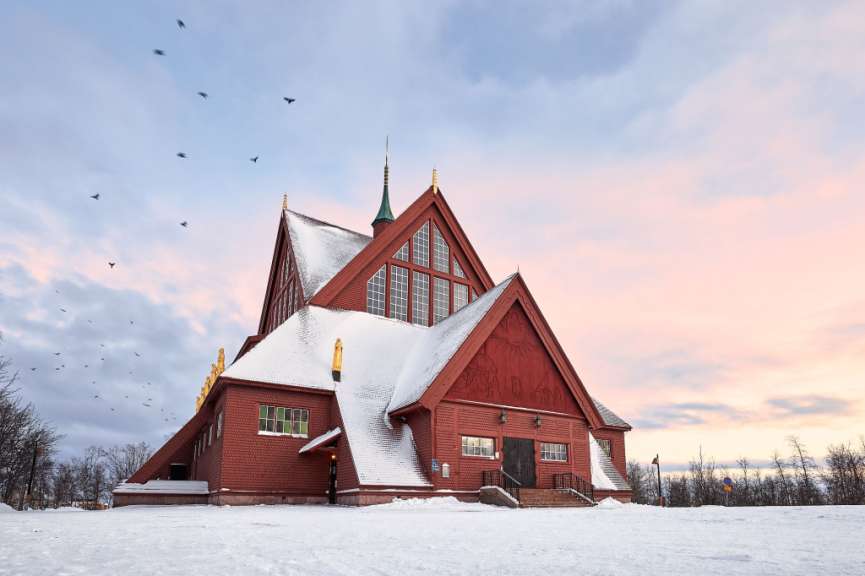 Eine rote Kirche mit schneebedecktem Dach