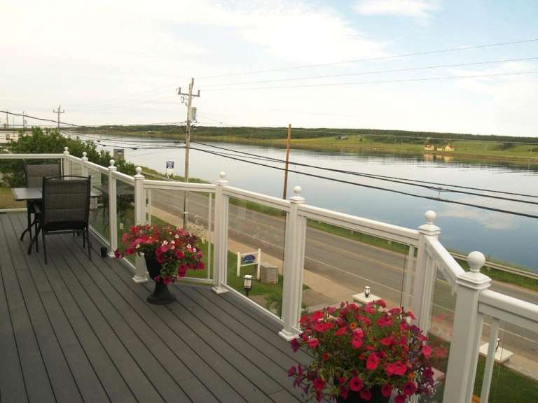 Ein Deck mit einem Tisch und Stühlen und einem Wasserblick