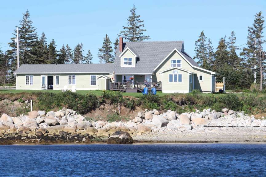 Ein Haus auf einem Hügel mit Blick auf das Wasser