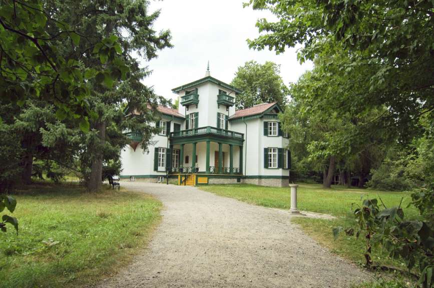 Ein großes weißes Haus mit grünen Fensterläden