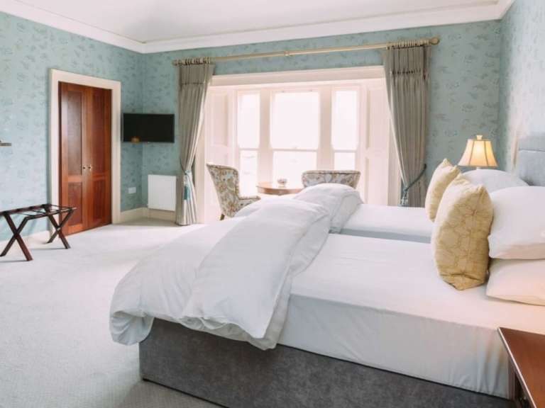 Ein Hotelzimmer mit zwei Betten und einem Fernseher