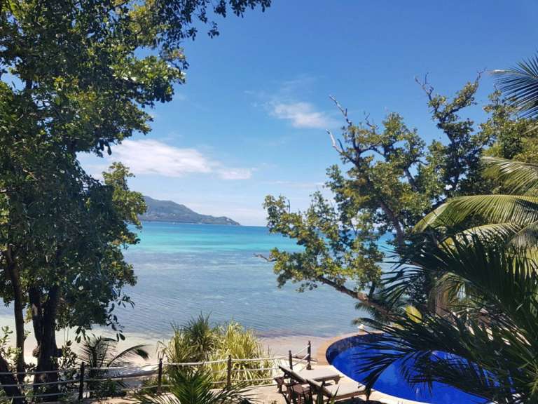 Ein Blick auf das Meer von einem tropischen Balkon mit Pool.